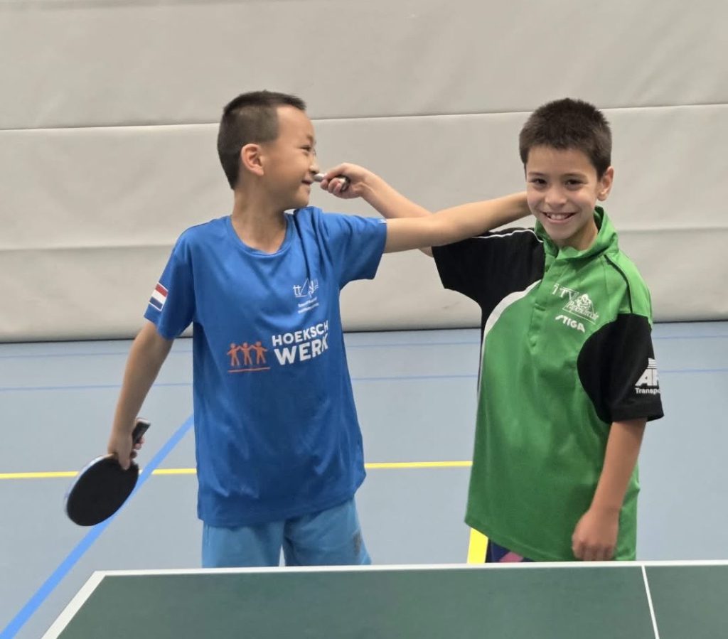 Twee jeugdspelers van Duo 1 pupillen met batje aan de tafeltennistafel